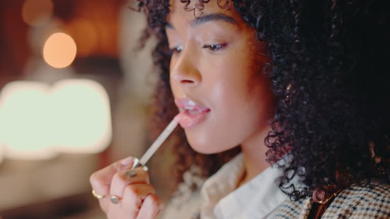 beauty makeup and a confident black woman using phone as a mirror to apply her lipstick